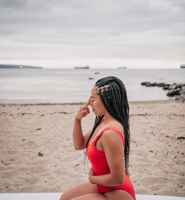 Person sitting in a meditative yoga pose looking serene and calm.